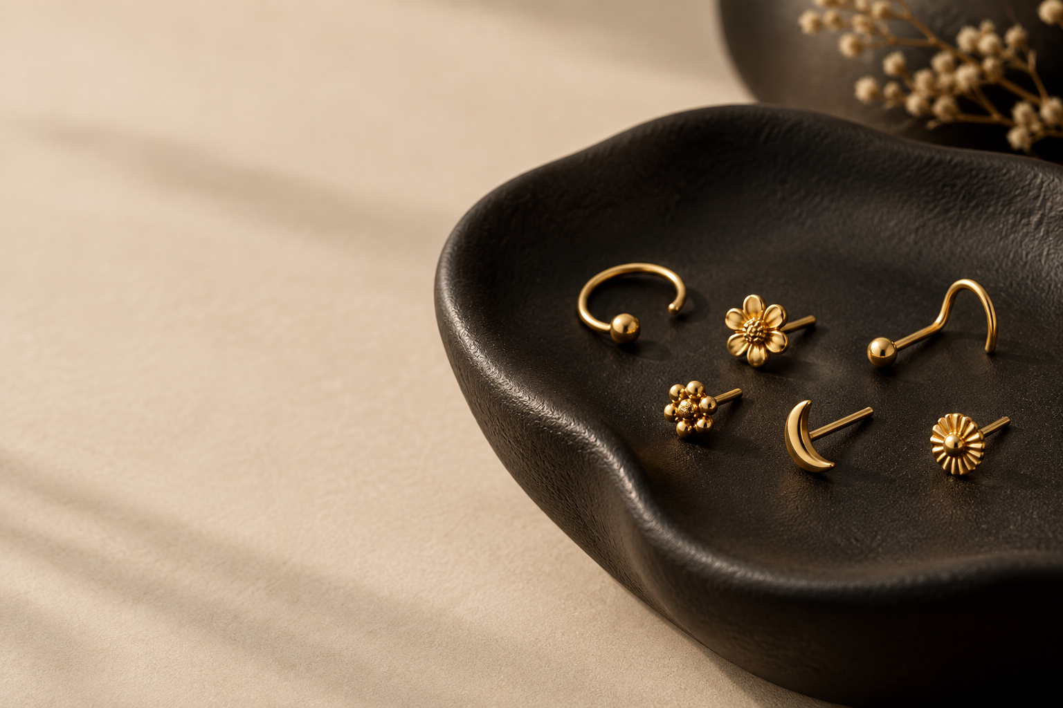 Illustrative editorial image of gold nose pins on a jewellery tray